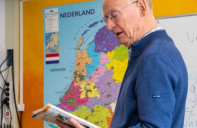 Een leraar die een lesboek vasthoudt in de klas