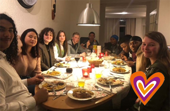 Groepje mensen gezellig aan het eten aan tafel in een van de jongerenhuizen